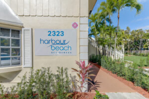 2323 harbour beach signage on exterior of building near sidewalks and greenery on sunny day